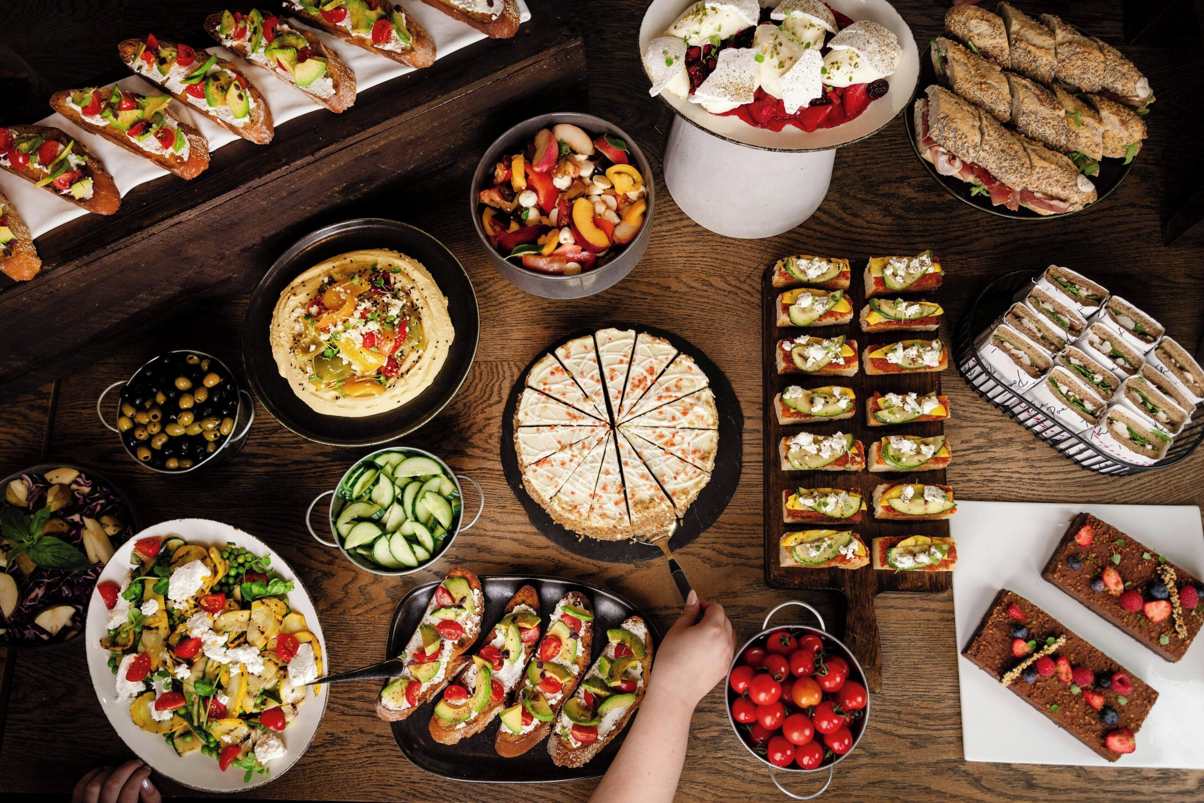 Variedad de alimentos, incluyendo tarta, sándwiches y ensalada.