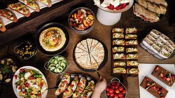 Variedad de alimentos, incluyendo tarta, sándwiches y ensalada.