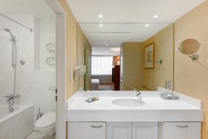 A modern bathroom with a bathtub, toilet, and a large mirror. - Marriott Executive Apartments Millennium Court (Budapest)