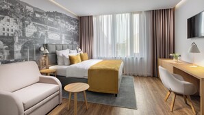 A modern hotel room with a bed, a sofa, a desk, and a TV. - Mamaison Residence Downtown (Prague)
