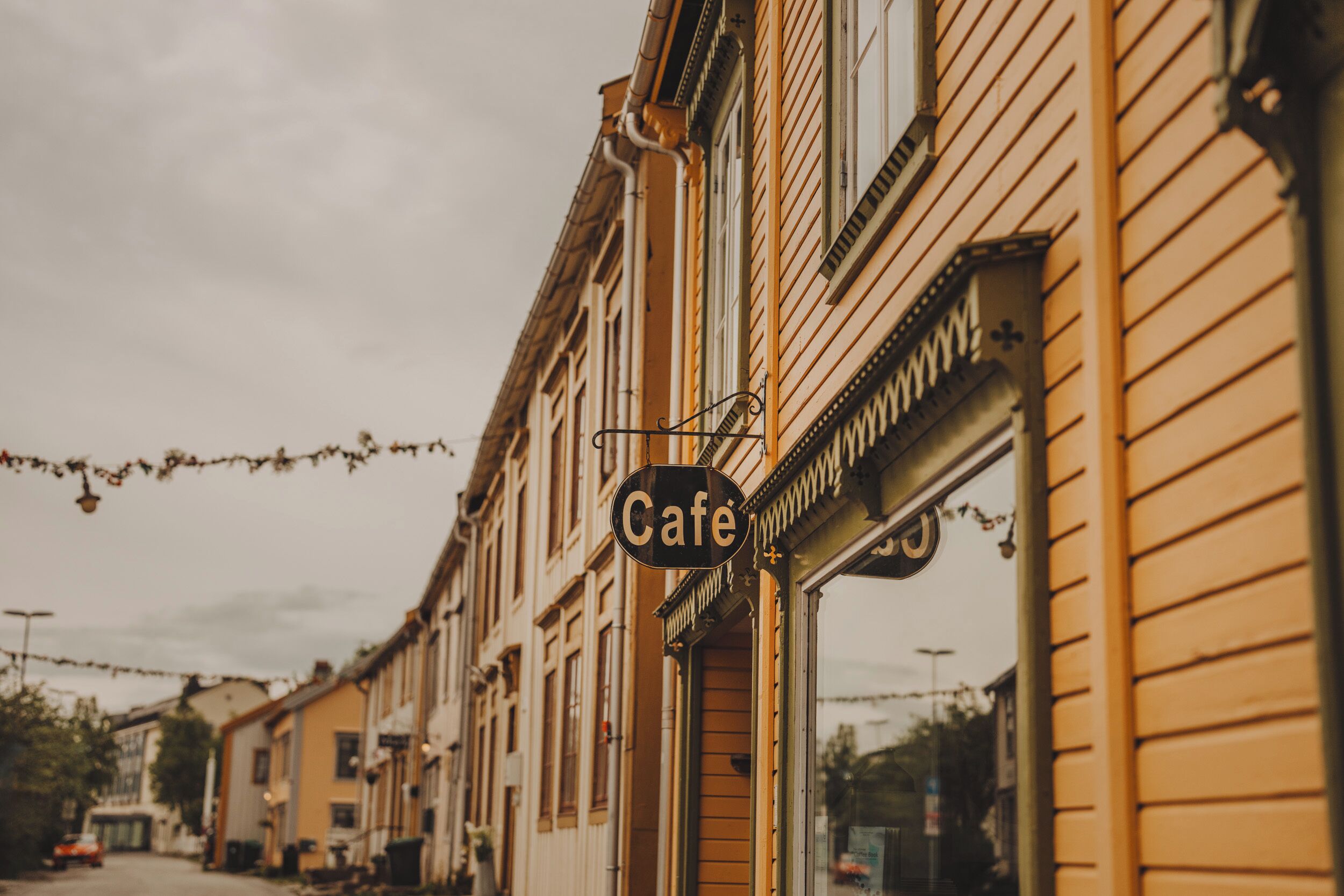 A street view with a cafe sign on a building.