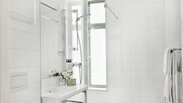 Un baño moderno con ducha, lavamanos y ventana.