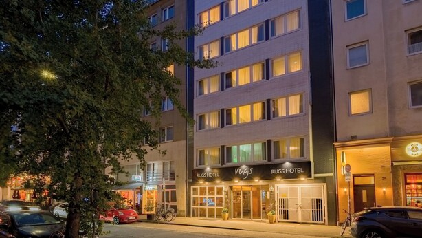 A multi-story hotel with a modern facade, large windows, and a ground-level restaurant. - Rugs Hotel Düsseldorf – Self Check- In (Düsseldorf)