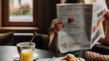 Ein Tisch mit einer Tasse Kaffee, einem Glas Orangensaft und Croissants.