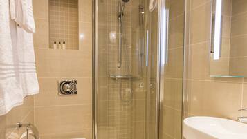 Un baño moderno con ducha envuelta en vidrio, inodoro y lavamanos.