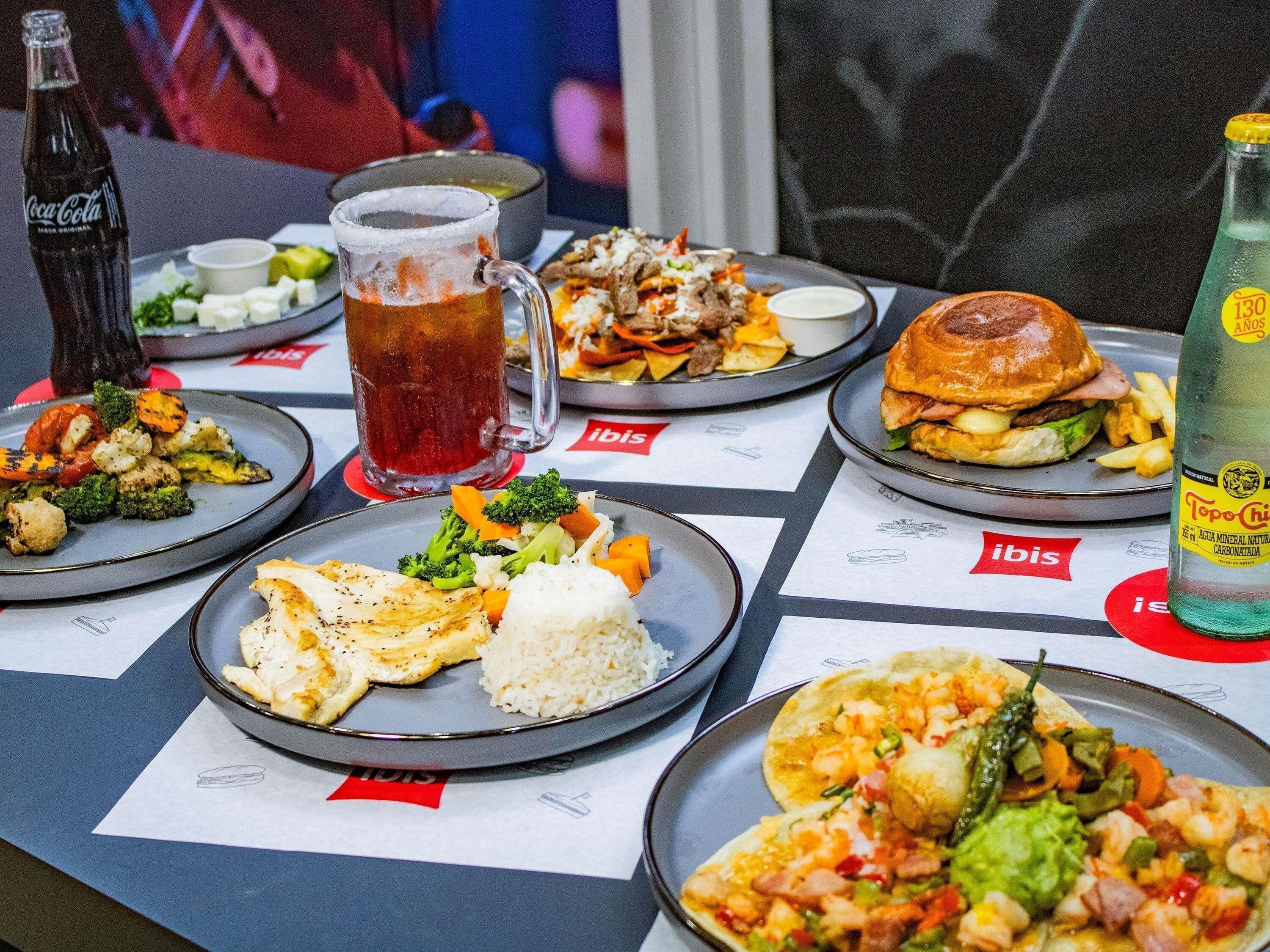 A table with various dishes, a beer mug, and a bottle of water.