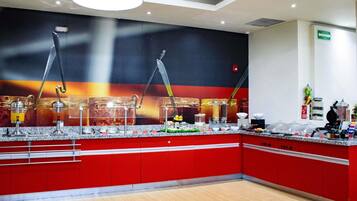 A modern kitchen area with a red and white color scheme, equipped with various appliances and utensils.