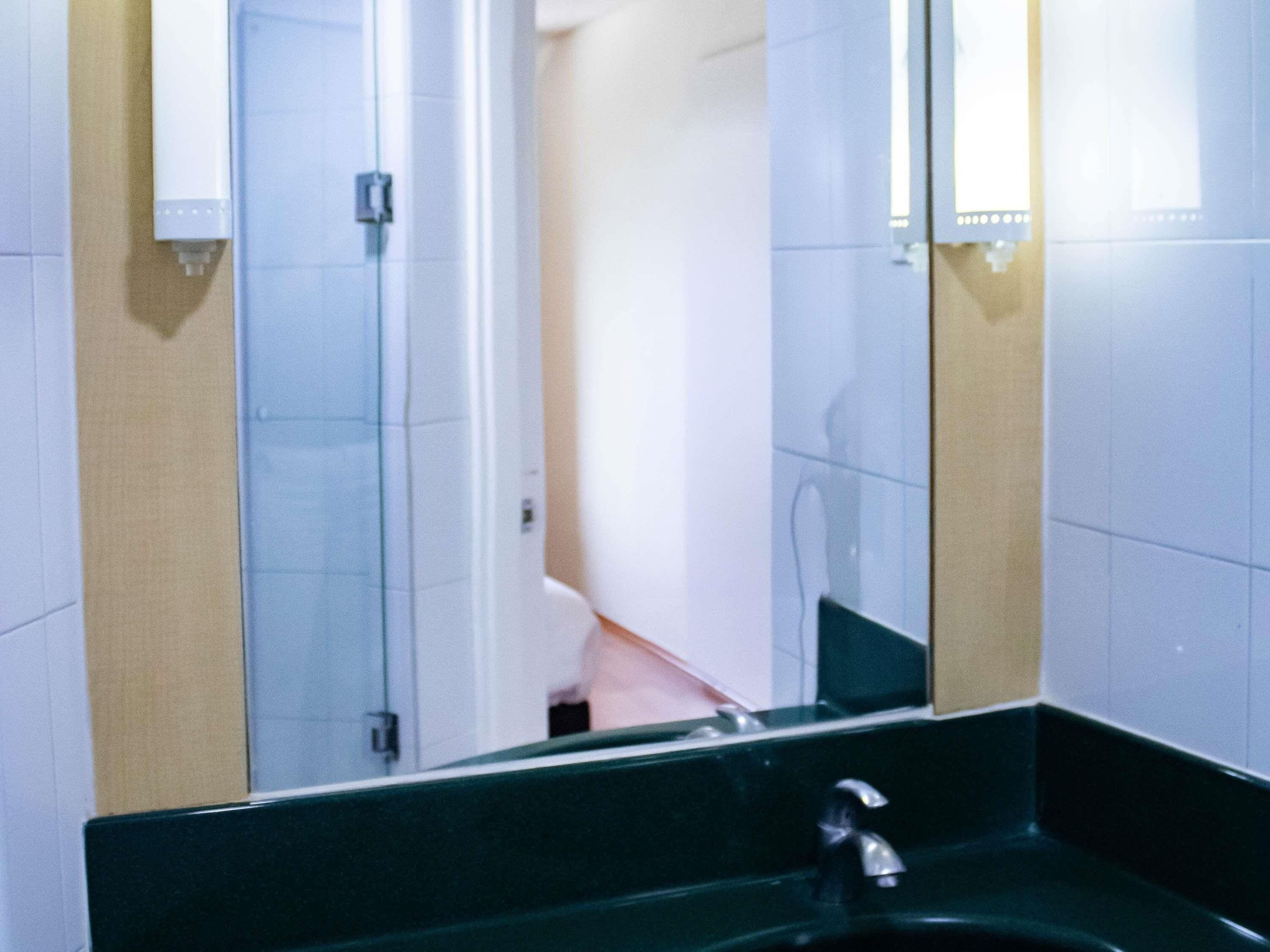 A bathroom with a sink, mirror, and towel rack.