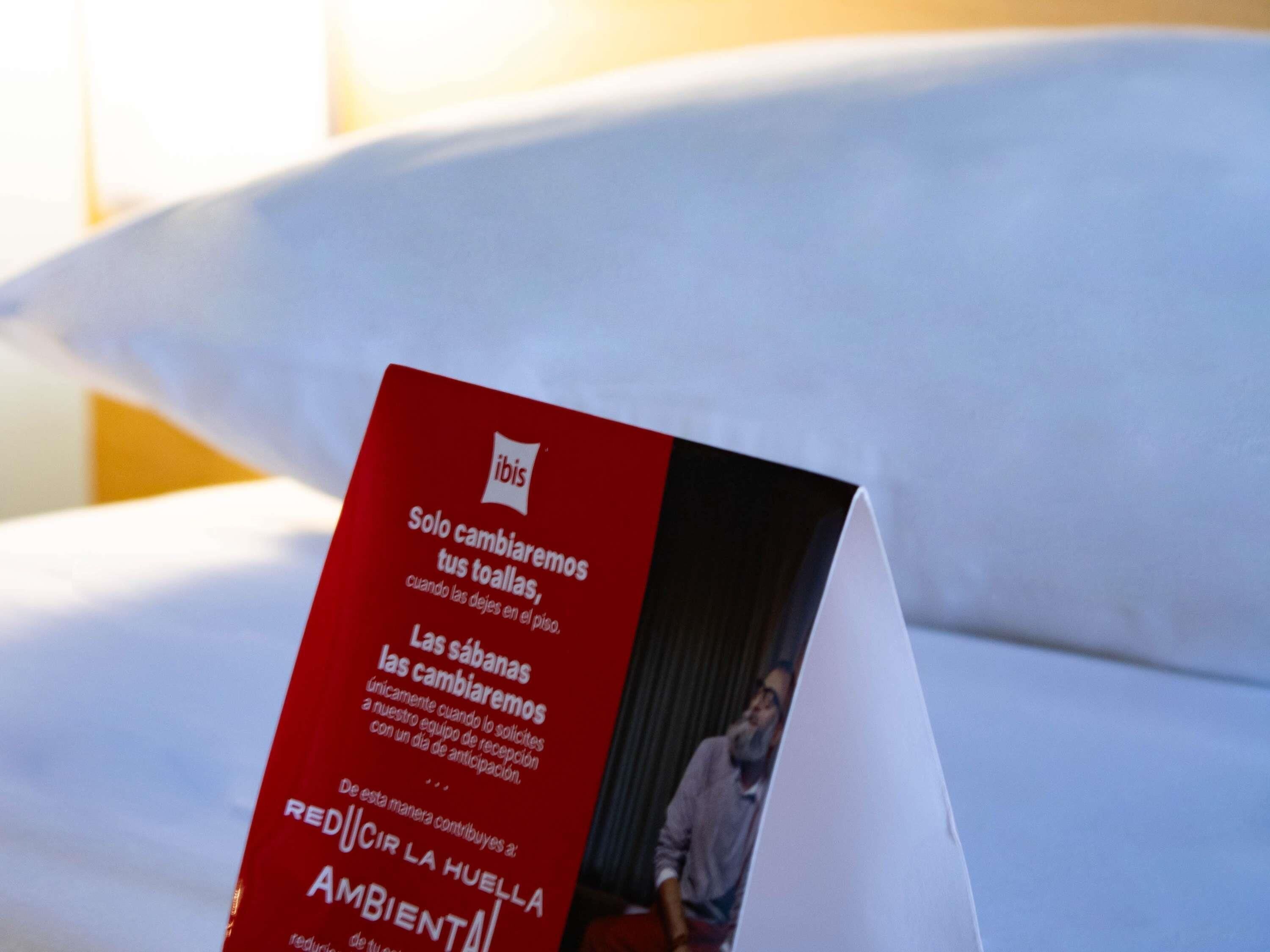 A red brochure with text and a logo, placed on a white surface.