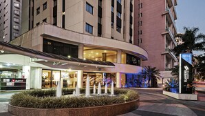 A hotel entrance with a fountain, a MultiPark sign, and a Slavero sign. - SLAVIERO Moema (São Paulo)