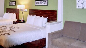 A hotel room with two beds, a nightstand with a lamp, and a sofa. - Sleep Inn & Suites Stony Creek - Petersburg South (Stony Creek)