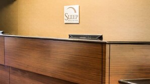 A reception desk with a sign that reads "Sleep Inn & Suites." - Sleep Inn & Suites Stony Creek - Petersburg South (Stony Creek)