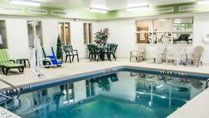 An indoor swimming pool with a 3 FT depth marker, surrounded by lounge chairs and a table with chairs. - Sleep Inn & Suites Stony Creek - Petersburg South (Stony Creek)