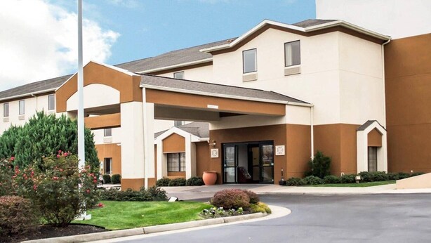 A Sleep Inn hotel with a modern design, featuring a prominent entrance, a covered parking area, and a well-maintained lawn. - Sleep Inn & Suites Stony Creek - Petersburg South (Stony Creek)