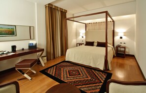 Relax in comfort with a four-poster bed, desk, and leather bench.