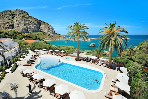 Una piscina al aire libre de temporada, sombrillas