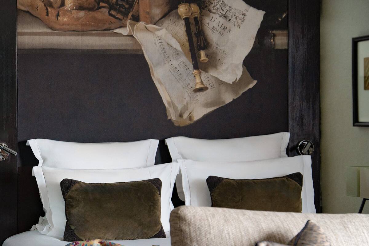 Ein Schlafzimmer mit einem Bett, Kissen und einer Wand mit einer Dekoration.