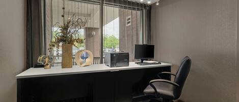 Un escritorio moderno con una computadora, una silla y elementos decorativos.