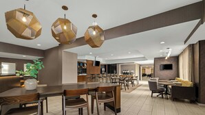 Een moderne eetruimte met hexagonale hanglampen, houten tafels en stoelen.