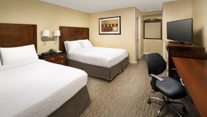 A hotel room with two beds, a desk, a chair, a television, and a framed picture on the wall. - American Inn Of Bethesda (Bethesda)