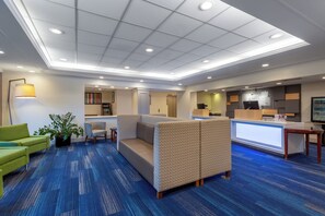 A hotel lobby with a reception desk, seating area, and a plant. - Holiday Inn Express Hotel & Suites Philadelphia – King of Prussia by IHG (King of Prussia)