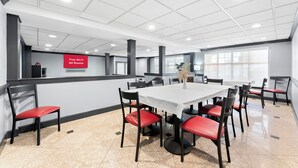 A conference room with a white table, red chairs, and a sign indicating free Wi-Fi in all rooms. - Red Roof Inn Lancaster (Lancaster)