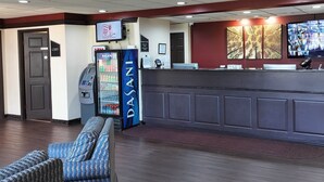 A reception area with a counter, a vending machine, a seating area, and a television screen. - Red Roof Inn Lancaster (Lancaster)