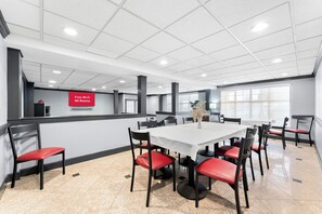 A conference room with a white table, red chairs, and a sign indicating free Wi-Fi in all rooms. - Red Roof Inn Lancaster (Lancaster)