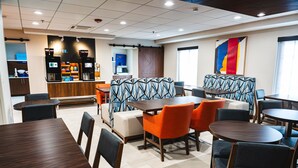 A modern hotel lobby with seating areas, a coffee bar, and a large abstract painting. - Holiday Inn Express Frazer - Malvern by IHG (Malvern)