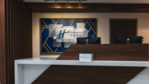 A reception desk with a modern design, a large sign for Holiday Inn Express, and a digital screen. - Holiday Inn Express Frazer - Malvern by IHG (Malvern)