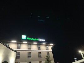 Edificio de Holiday Inn Express iluminado durante la noche con señalización.