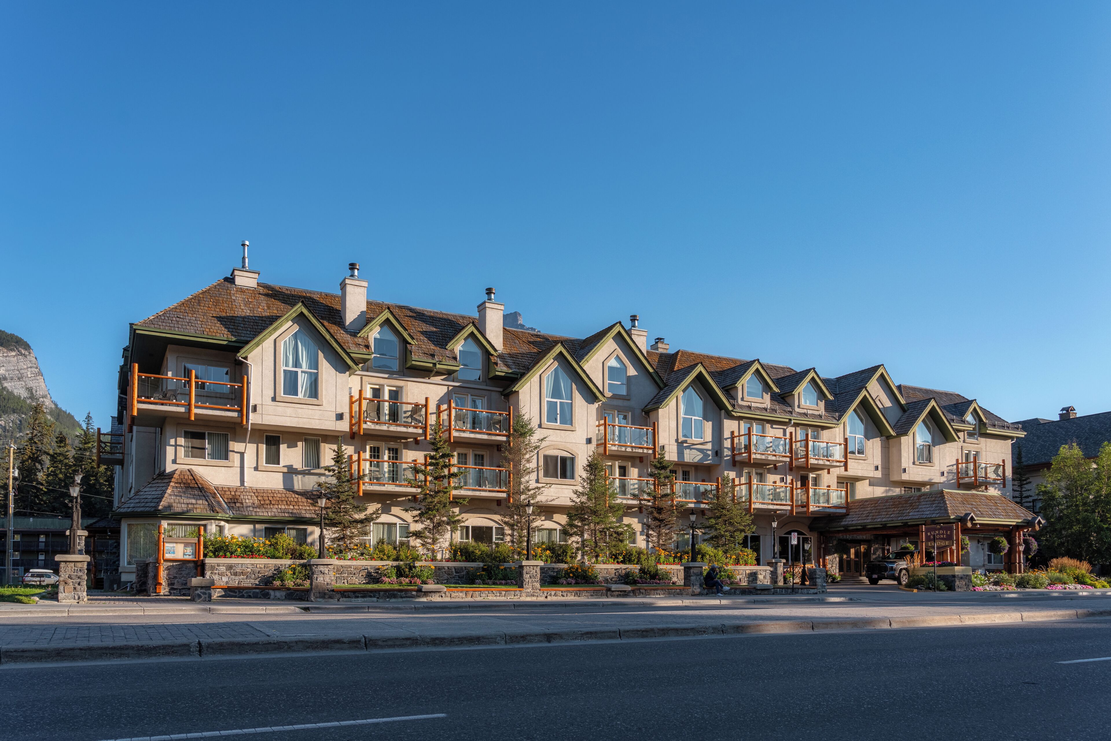 A multi-story hotel with a symmetrical facade, balconies, and a stone facade.