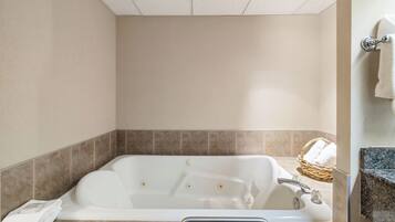 Un baño con bañera, una toalla y una cesta de mimbre.