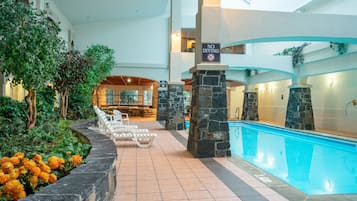 Una piscina techada, sillones reclinables de piscina