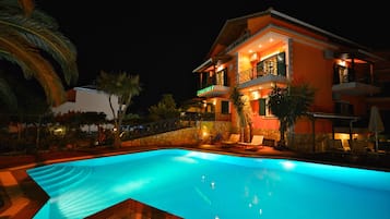A two-story building with a swimming pool in front.
