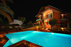 Un edificio de dos pisos con una piscina delantera.