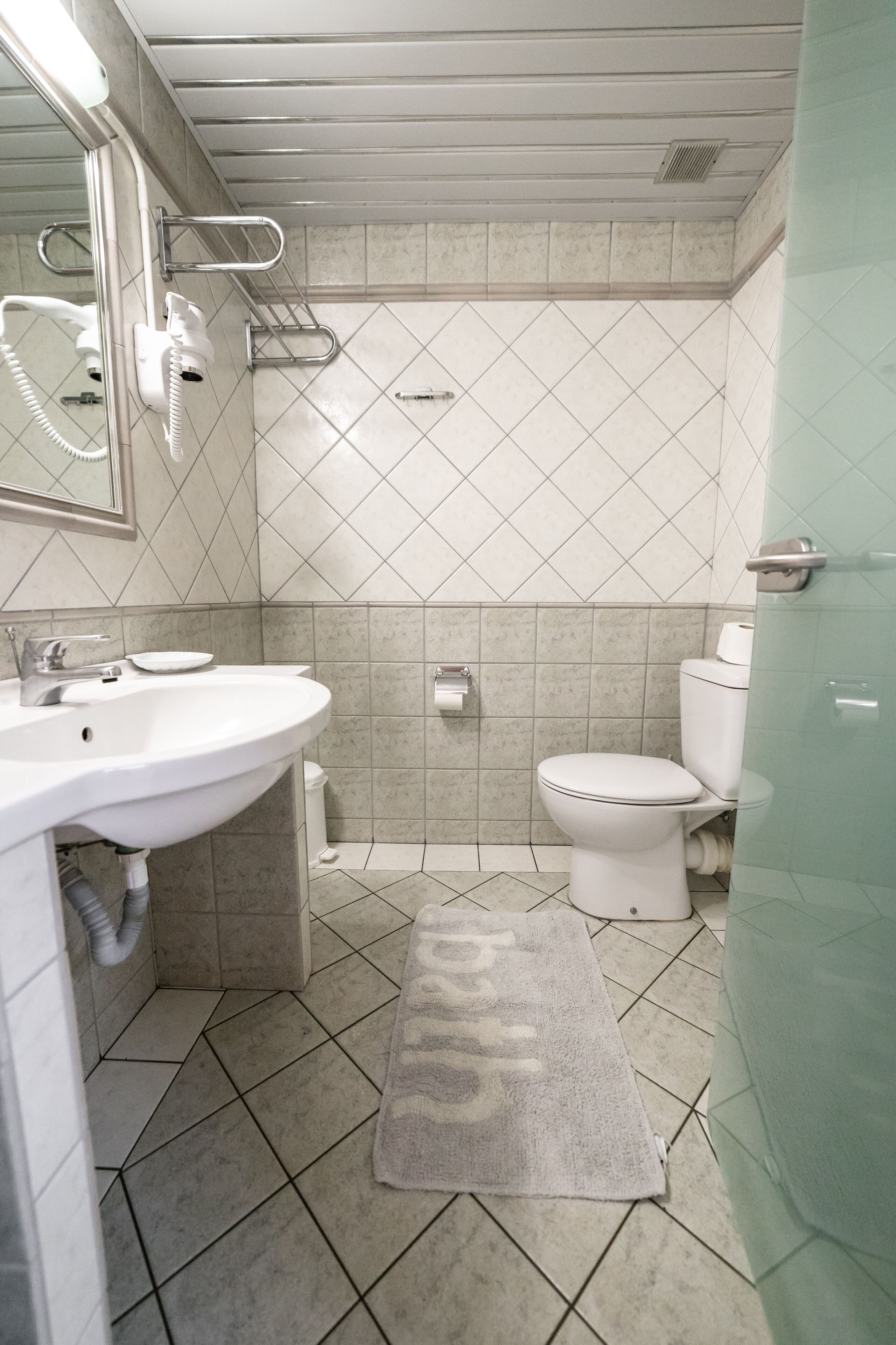 A bathroom with a sink, toilet, and shower.