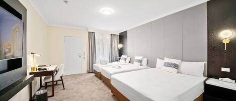 A hotel room with a large bed, a desk, a chair, and a TV.
