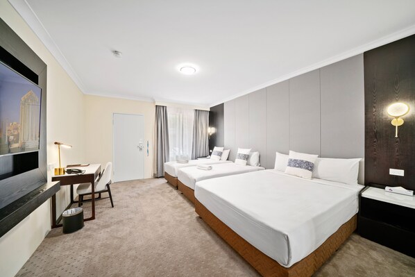 Una habitación de hotel con una cama grande, un escritorio, una silla y un televisor.
