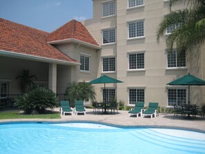 Una piscina al aire libre, sombrillas