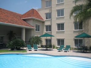 Una piscina al aire libre, sombrillas