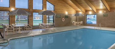 Una piscina techada, sillones reclinables de piscina