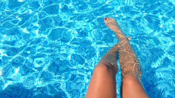 A pool with clear blue water and a person's legs in the water. - Mercure Newcastle (Newcastle West)