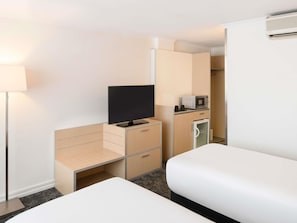 A hotel room with a bed, a desk with a flat-screen TV, a microwave, and a refrigerator. - Mercure Newcastle (Newcastle West)