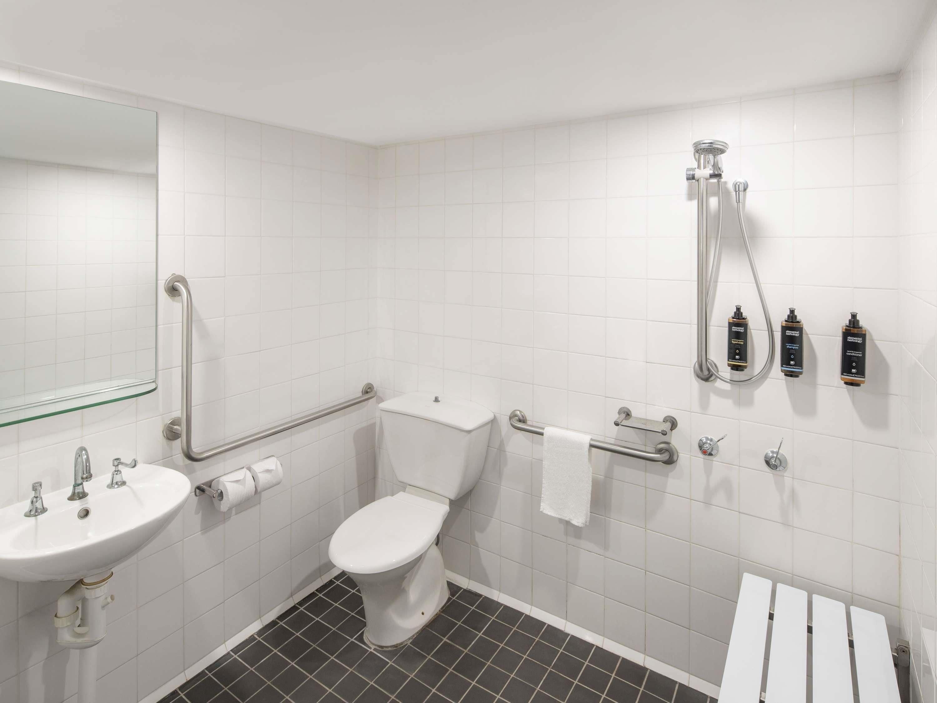 A bathroom with a white sink, toilet, and shower area.