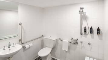 A bathroom with a white sink, toilet, and shower area.