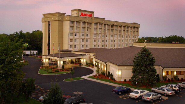 A Marriott hotel with a central courtyard, multiple parking lots, and a large building with a prominent sign.
