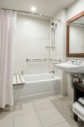 A bathroom with a bathtub, shower, and sink.