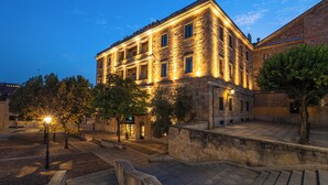 Un edificio histórico con patio, muros de piedra y entrada bien iluminada.