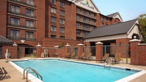 Una piscina junto a un edificio de ladrillo con un letrero que dice "Hyatt Place".